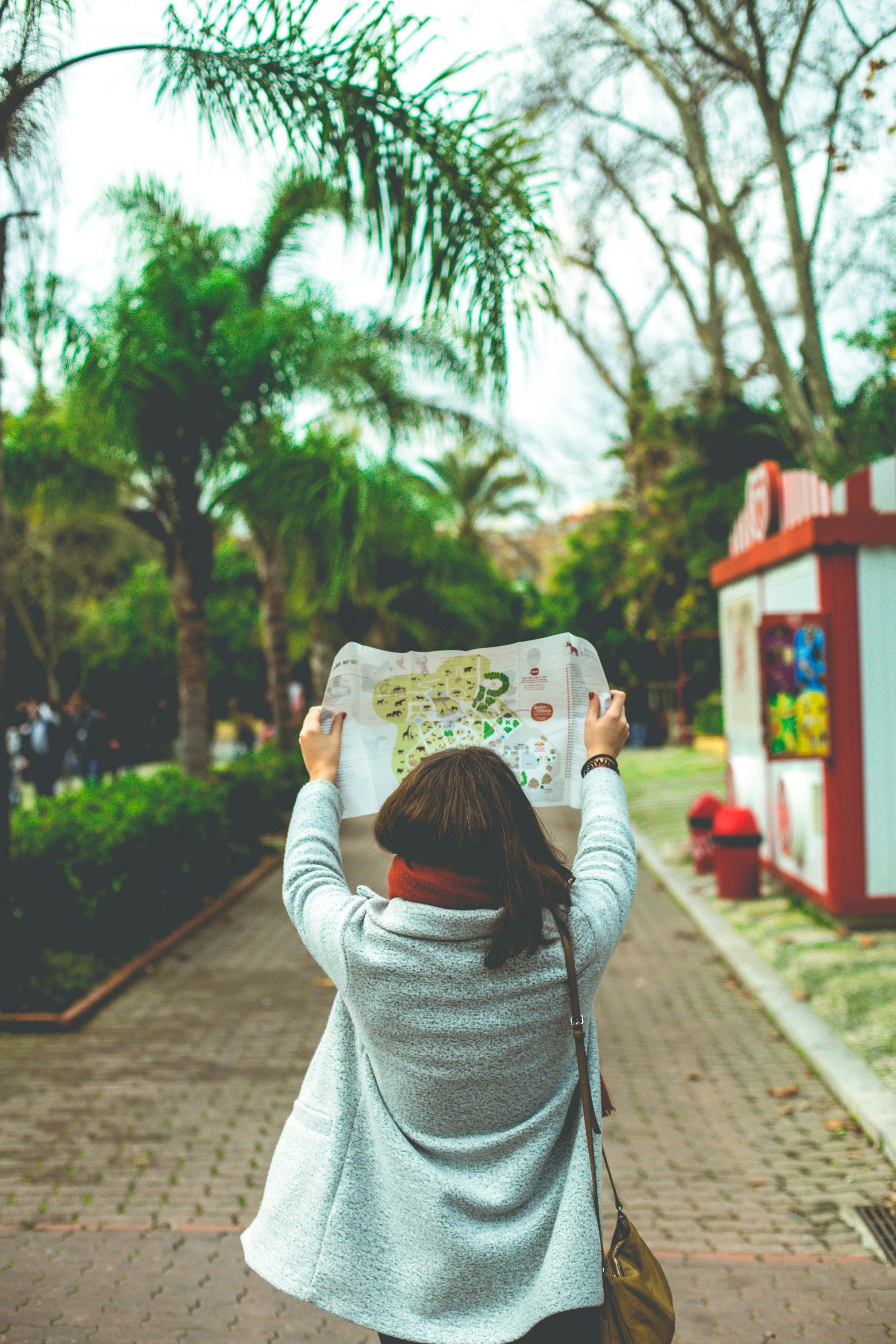 Image with a kid which is reading a map.